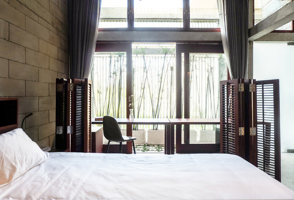 Góc làm việc trong phòng ngủ ngập tràn ánh sáng tự nhiên, hướng nhìn ra mảng xanh.