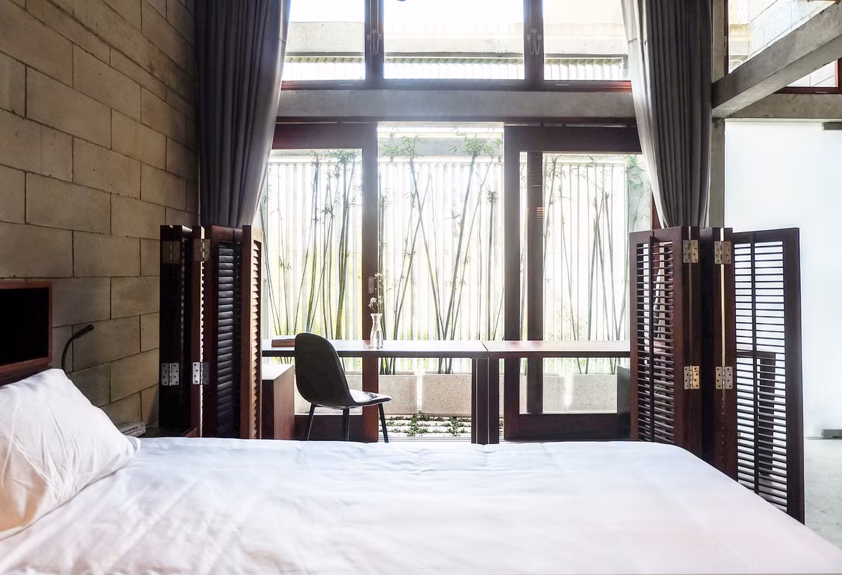 Góc làm việc trong phòng ngủ ngập tràn ánh sáng tự nhiên, hướng nhìn ra mảng xanh.