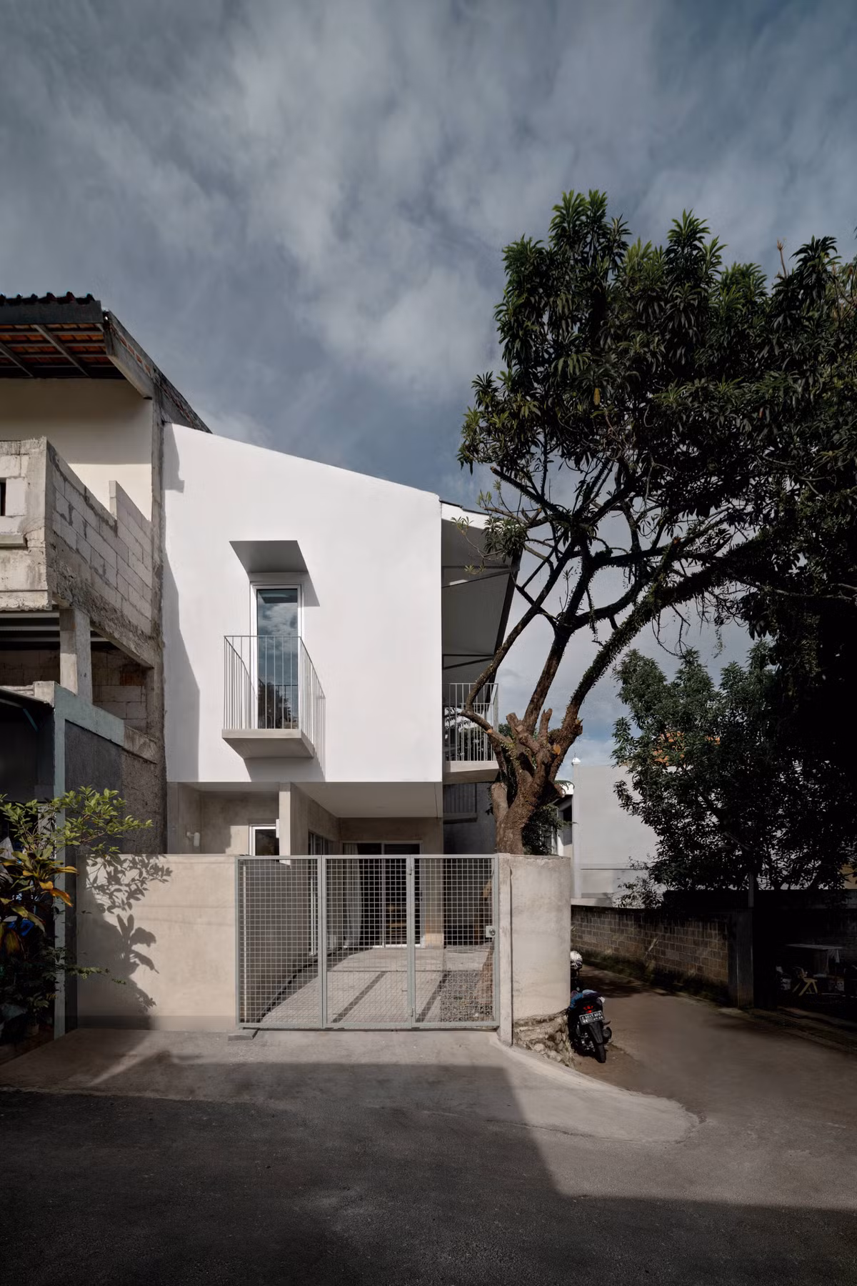 Dù vậy, kiến trúc sư vẫn dành ra một khoảng sân nhỏ phía trước vừa làm nơi để ô tô gia đình, vừa để trồng cây xanh lấy bóng mát.