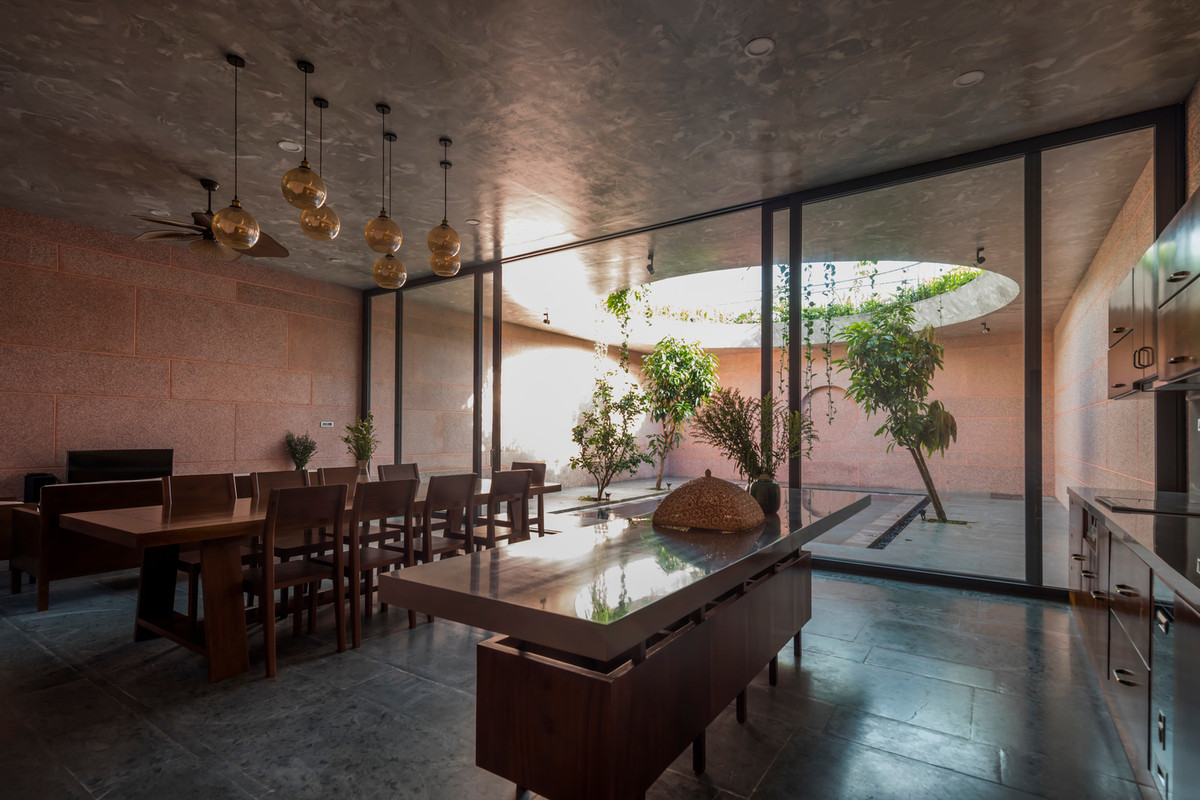 Phòng khách và nhà bếp ăn được liên kết, hướng ra hồ bơi, nơi chuyển tiếp ánh sáng giữa ngày và đêm.