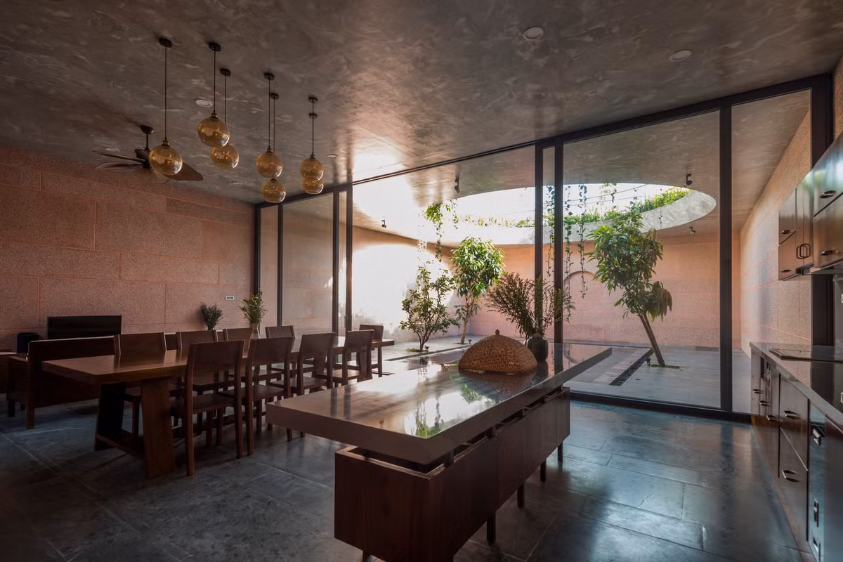 Phòng khách và nhà bếp ăn được liên kết, hướng ra hồ bơi, nơi chuyển tiếp ánh sáng giữa ngày và đêm.