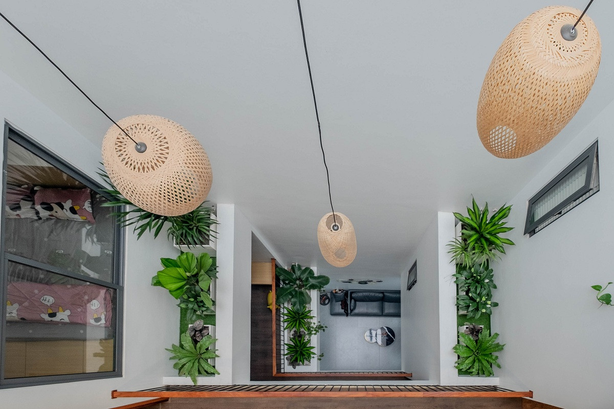 Giếng trời giữa nhà có xu hướng rộng hơn ở các tầng trên giúp gắn kết không gian phòng ngủ, cầu thang, đồng thời lấy được nhiều ánh sáng hơn.