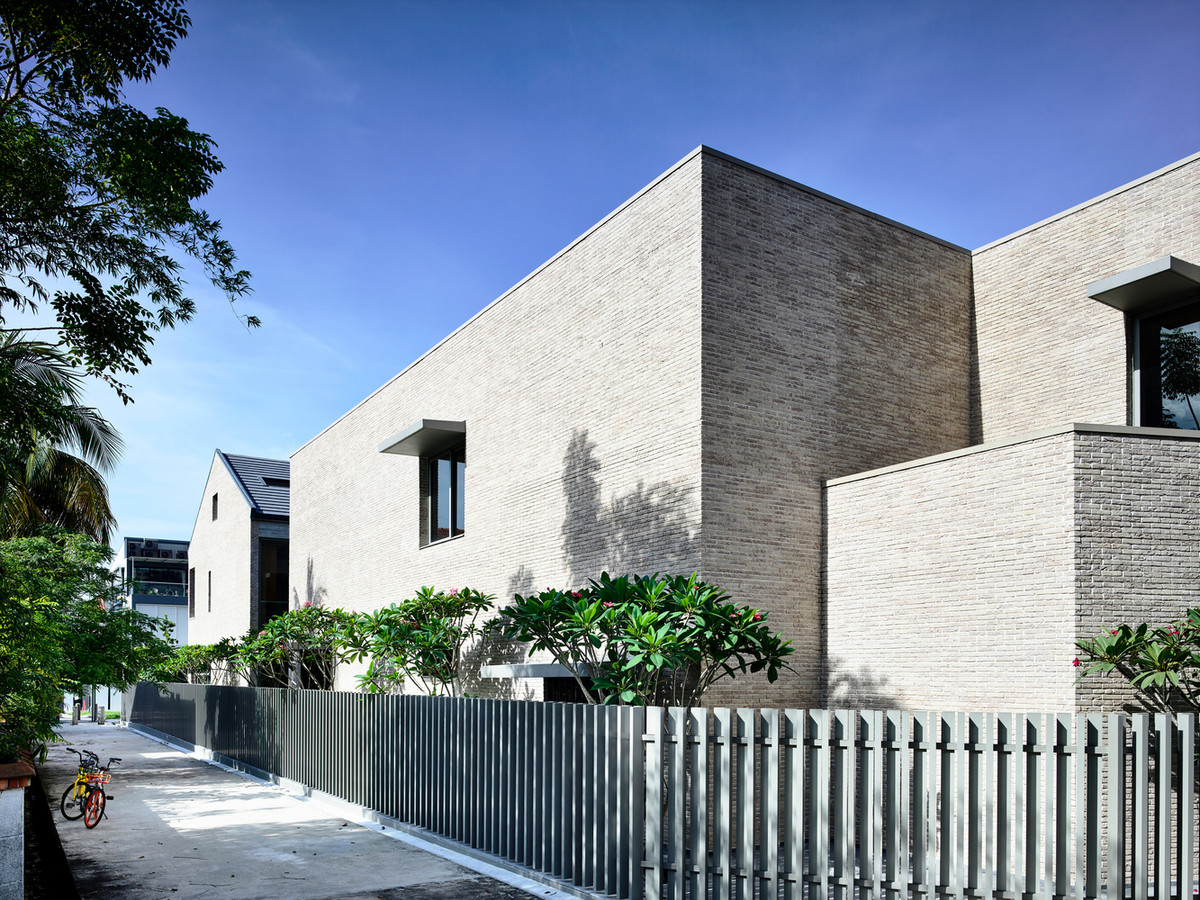 Tường gạch trơn không trát vữa với tông màu trung tính giúp giảm bớt cảm giác thô cứng, nặng nề của một công trình hướng nội.