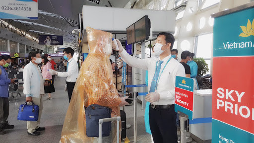 Đại dịch COVID-19 ập tới, nghề kiểm tra thân nhiệt cũng trở thành công việc có mức thu nhập tốt và không cần bằng cấp. Ảnh: Ảnh: VNA