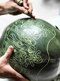 Khoảng 20 - 29 tháng Chạp hàng năm, những người thợ chạm khắc lại tất bật chạm khắc những hình ảnh, câu chúc Tết ý nghĩa lên quả dưa. Ảnh: Viannet.