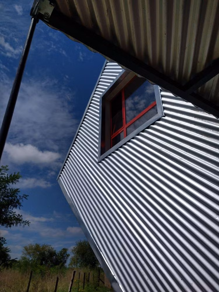 Nhà có mái dốc và một khối hộp bị đổ nghiêng.