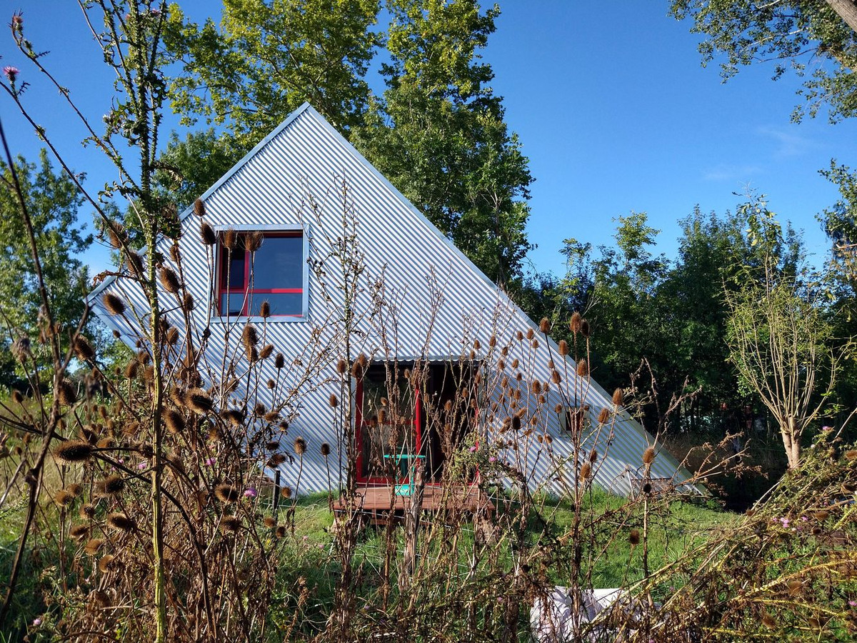 Được quây quanh bởi nhiều tấm thép, nhìn từ bên ngoài vào căn nhà như một sự kín đáo hoàn toàn.