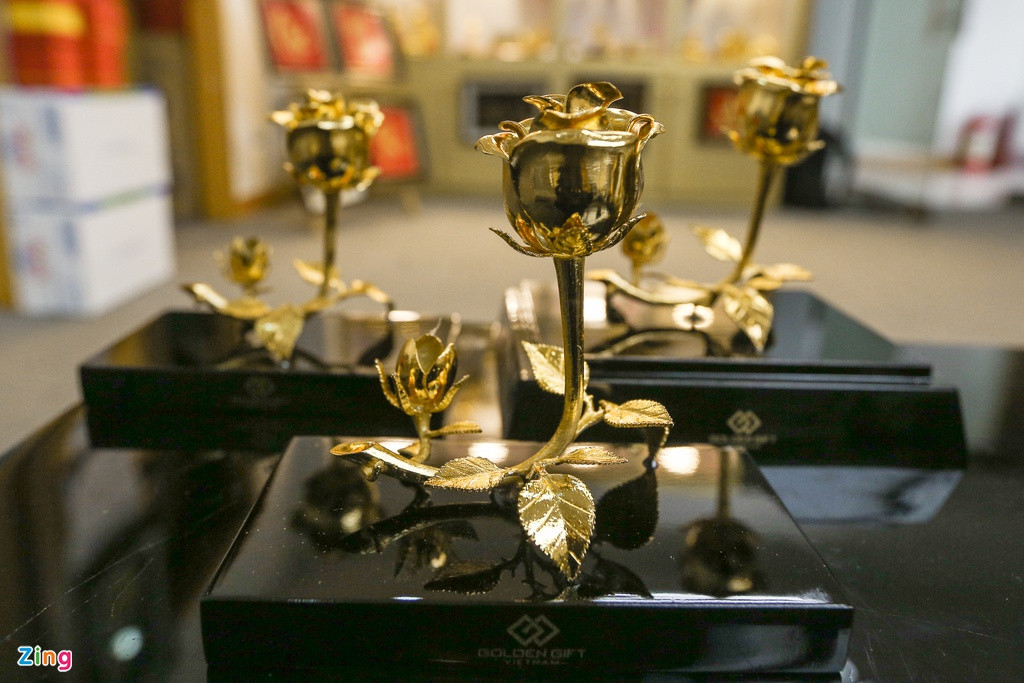 Nhân viên cửa hàng cho biết các sản phẩm ở đây đều được sử dụng công nghệ điện phân mạ vàng 24k. Tượng, hoa, khuy cài áo được đúc thủ công bằng đồng và mạ vàng 24k. Trong hình là sản phẩm bông hồng nghệ thuật 3 trong một có giá 2,5 triệu đồng.