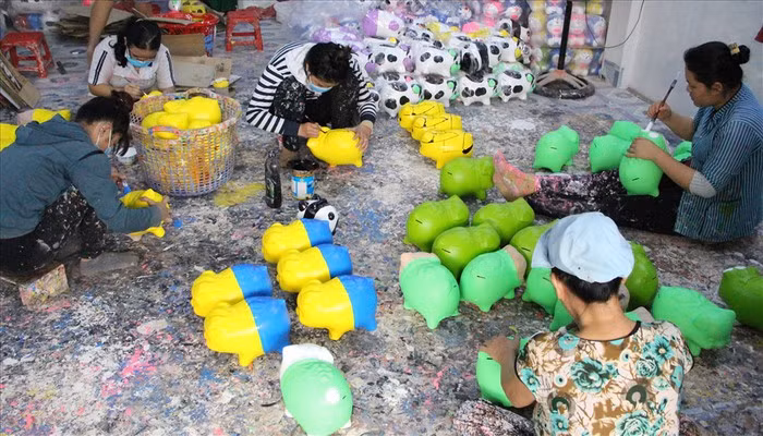 Công đoạn sơn vẽ cho heo đất. Ảnh: Lao động.