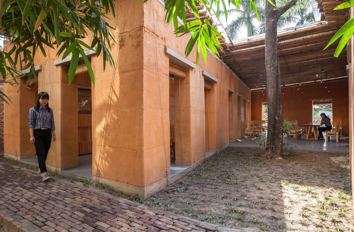 Tường đất dày 40cm, mái lợp tre, xung quanh là cây xanh thể hiện sự gắn bó, hòa hợp với thiên nhiên.