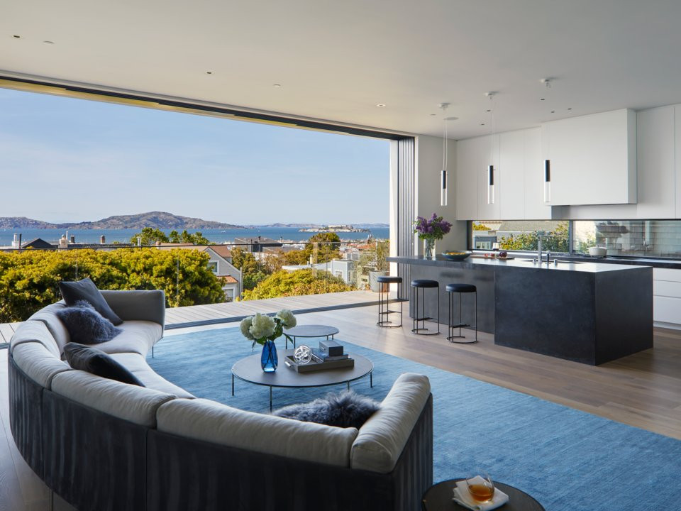 Nhà bếp có trần cao và tường kính mở ra sân thượng.