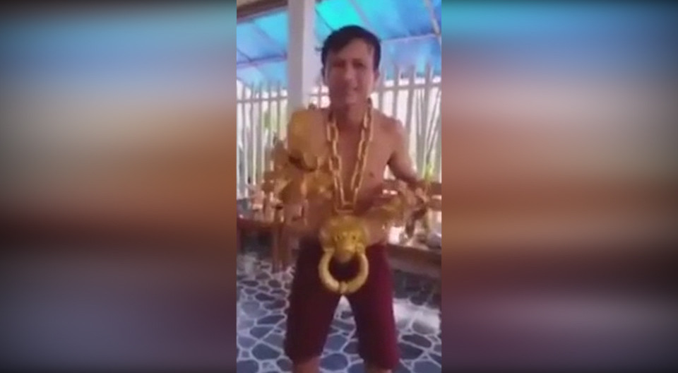 Theo đoạn clip, người đàn ông với dáng người gày gò, đeo 1 dây chuyền vàng bằng sợi xích, nặng 10 kg với mặt dây chuyền hình Hổ Phù. Ảnh: Youtube.