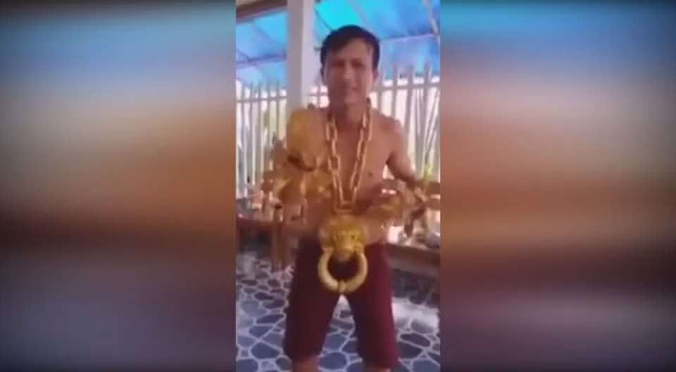 Theo đoạn clip, người đàn ông với dáng người gày gò, đeo 1 dây chuyền vàng bằng sợi xích, nặng 10 kg với mặt dây chuyền hình Hổ Phù. Ảnh: Youtube.