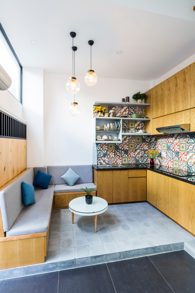 Nhà bếp và sofa được đặt cạnh nhau. Cách bài trí gọn gàng, ngăn nắp.