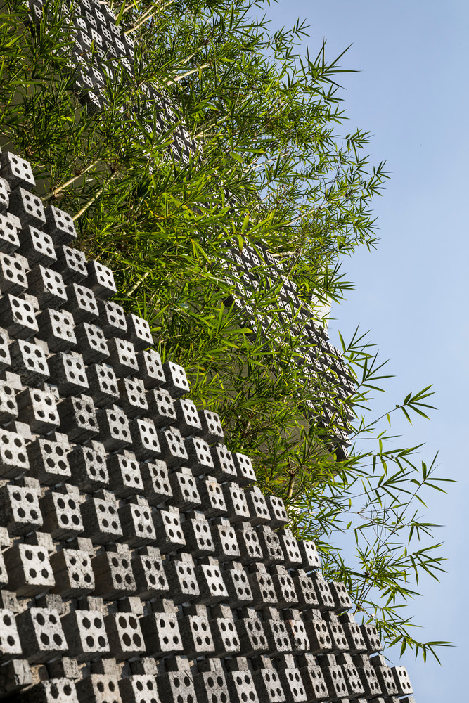 Mặt tiền nổi bật với chất liệu gạch hoa thông gió bê tông xen kẽ cây xanh.