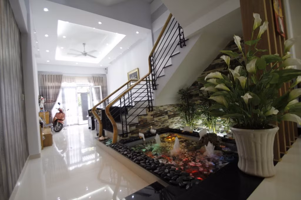 Tiểu cảnh nước trong sân bố trí khéo léo dưới chân cầu thang.