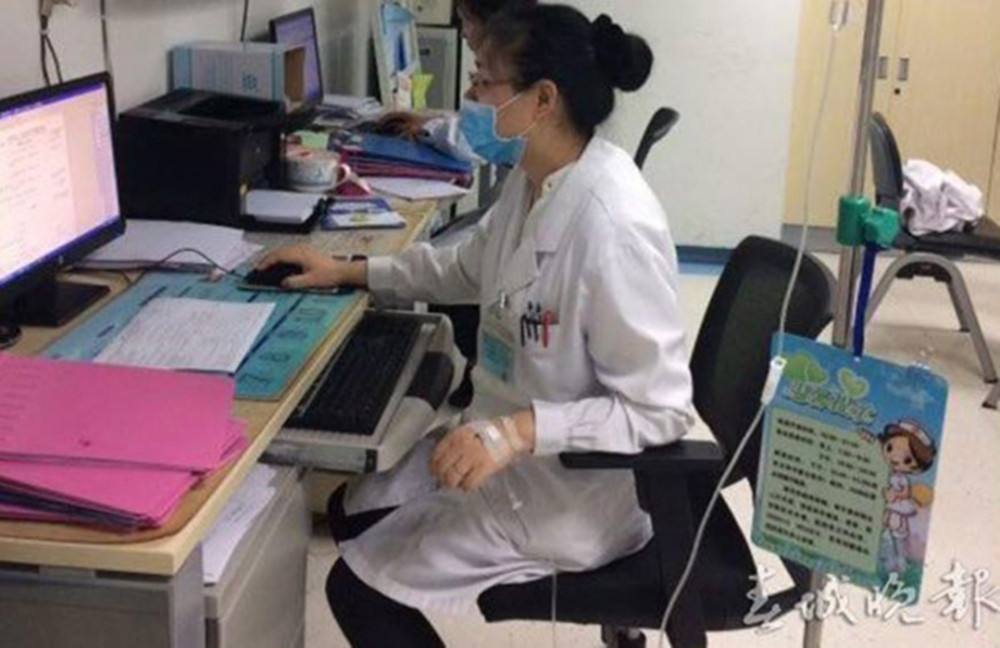 Vào sáng 31/5/2017, Đặng Gia Hùng, một bác sĩ tại Bệnh viện Nhân dân số 1 của tỉnh Vân Nam trực ca đêm. Trọng một đêm cô đã tiếp nhận hơn 10 bệnh nhân, sau khi giao ca cô đã không về nhà. Ở bệnh viện cô vừa truyền nước, vừa nhập dữ liệu bệnh án, bức ảnh này được chụp bởi một bệnh nhân. Bác sĩ Đặng Gia Hùng nói, thật sự tình huống này là điều rất bình thường ở bệnh viện, rất nhiều bác sĩ và y tá sau khi bản thân phát bệnh cũng đều sẽ làm như vậy.