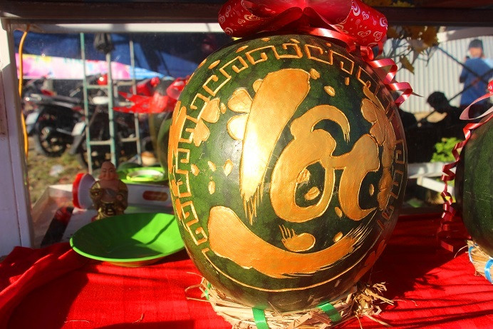 Sau khi khắc xong chữ thì người thợ sẽ phủ lên dưa hấu lớp sơn nhũ để tạo điểm nhấn, thu hút khách hàng.