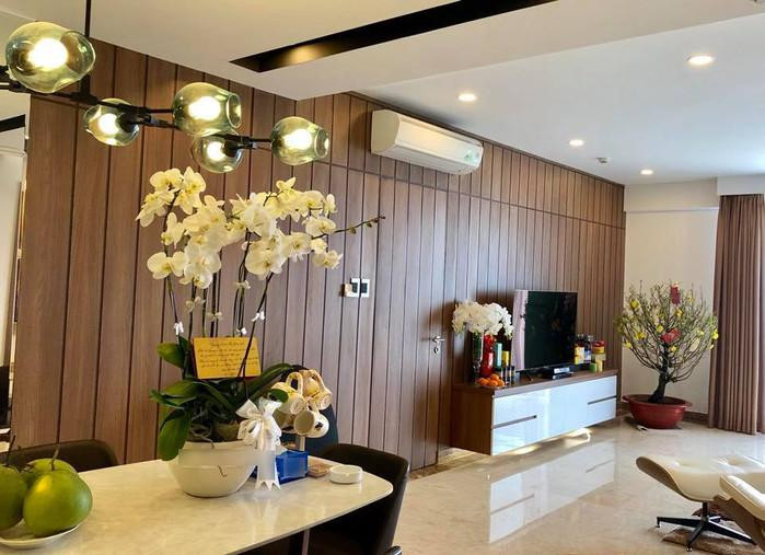 Toàn bộ khu vực tường phòng khách được ốp gỗ nâu rất sang trọng. Ảnh: Khám phá.