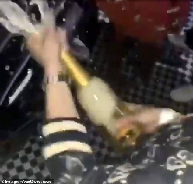 Một thanh niên khui chai Cristal giá 150 bảng (4,5 triệu đồng) để rửa xe.