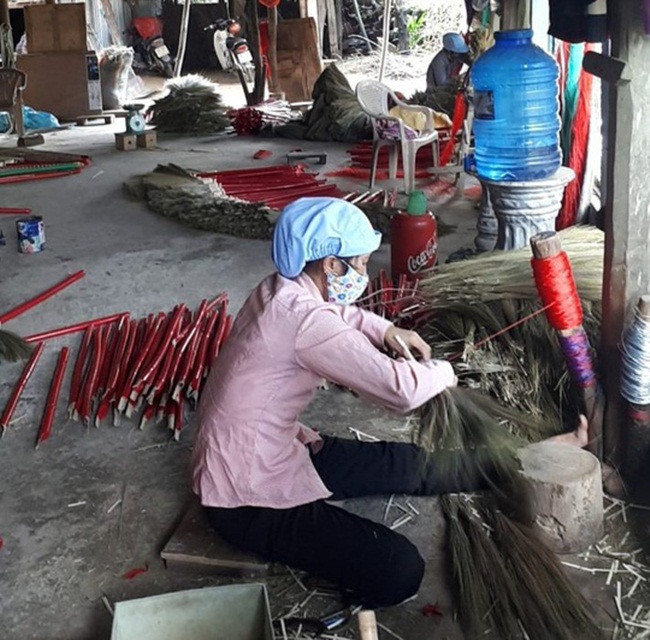 Sau khi thu được đót khô mới bắt đầu bện. Khi bện xong, chổi sẽ được làm sạch phần bụi đót. (Ảnh Người Lao Động).