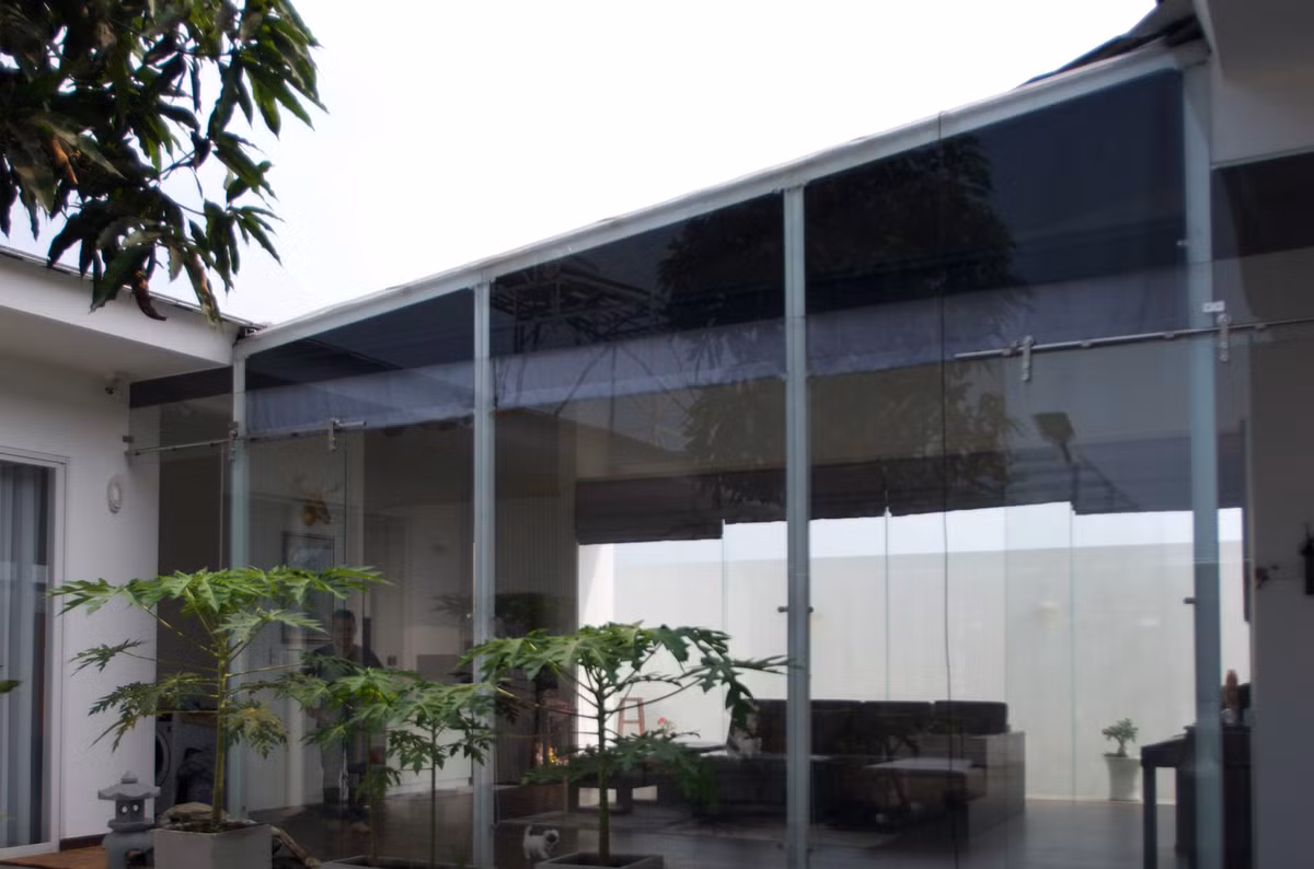Một phần kính của mái được gập xuống tạo thành bức tường ngăn cách phòng khách và sân trong, tạo sự riêng tư mà vẫn đảm bảo lấy ánh sáng.