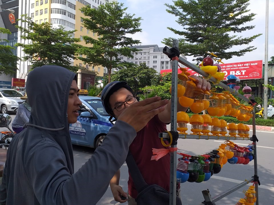 Trả lời báo Lao động, anh Hoàng Anh Tú nói: "Tôi làm nghề bán rau là chính, mấy hôm nay thấy lò xo mặt cười đang được mọi người tìm mua nhiều nên tôi chuyển qua bán thời vụ. Trung bình mỗi ngày tôi có thể bán ra hàng trăm chiếc lò xo mặt cười". Ảnh: Lao động.