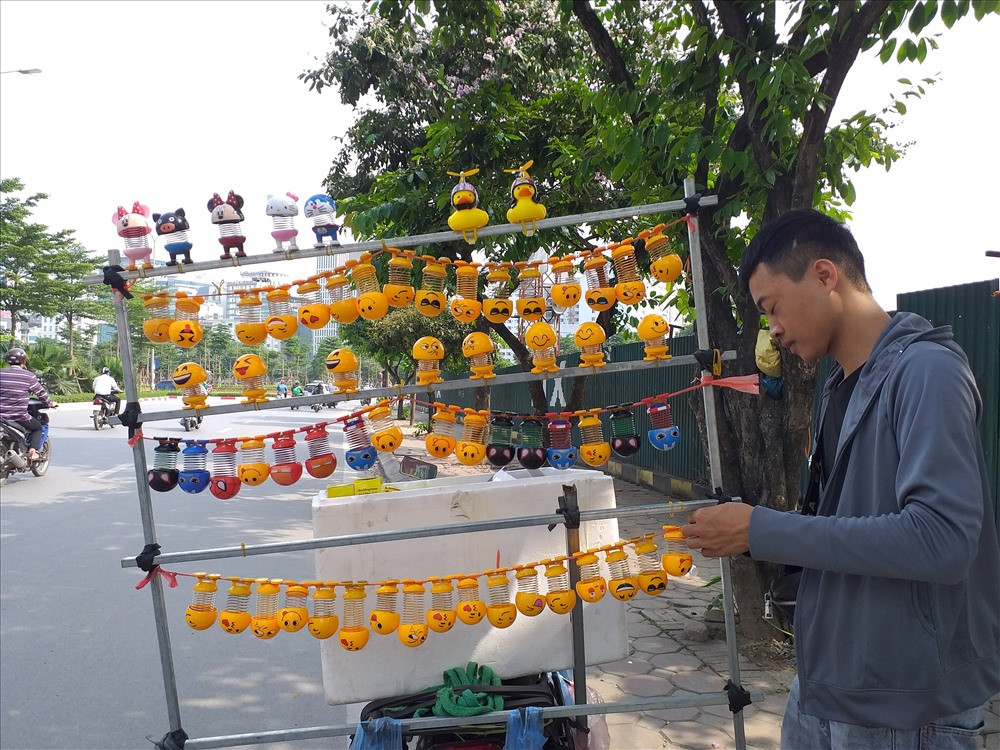 Trên một số tuyến phố ở Hà Nội, những chiếc lò xo với nhiều biểu cảm khuôn mặt ngộ nghĩnh được bày bán tràn lan. Ảnh: Lao động.