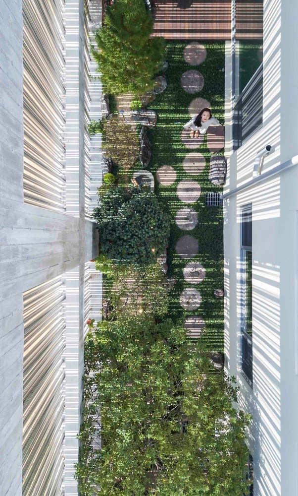 Vườn cây như một bước đệm phân chia bãi đỗ xe chật chội bên ngoài cuộc sống yên bình bên trong.