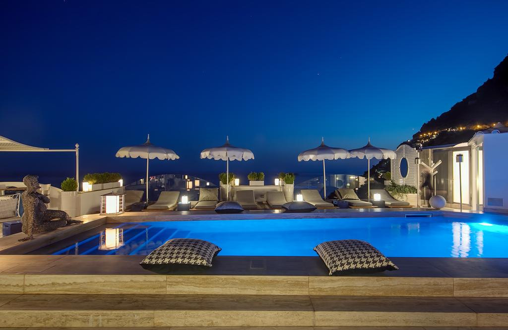 Du khách có thể nằm thư giãn dưới ô che nắng bên hồ bơi trên tầng mái và thưởng thức khung cảnh tuyệt đẹp. Ảnh: Booking.