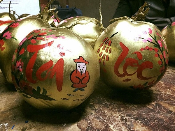 Nét chữ thư pháp màu đỏ, tím mềm mại lướt trên trái dừa cùng họa tiết cánh đào, hoa mai đặc biệt ấn tượng với người tiêu dùng. Ảnh: Motthegioi.