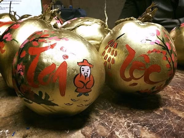 Nét chữ thư pháp màu đỏ, tím mềm mại lướt trên trái dừa cùng họa tiết cánh đào, hoa mai đặc biệt ấn tượng với người tiêu dùng. Ảnh: Motthegioi.