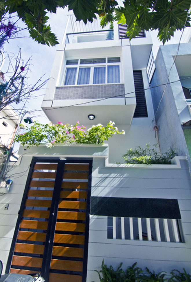 Mặt tiền sử dụng sơn màu trắng cửa kính có rèm xanh chắn nắng gay gắt ở hướng Tây. Ảnh: Xaynhasaigon.