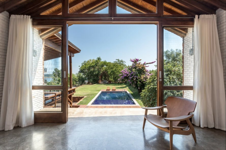 Cửa trượt tại phòng khách mở ra một hồ bơi ngoài trời và khu vườn rộng lớn phía sau.