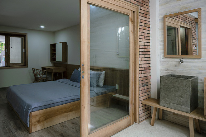  Phòng ngủ thoáng sáng với cửa kính lớn và khu vườn phía sau.