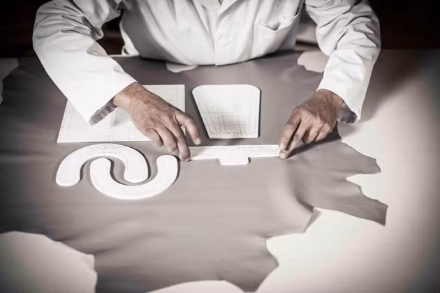 Dựa trên bản vẽ thiết kế, người thợ sẽ cắt trên vật liệu da truyền thống.