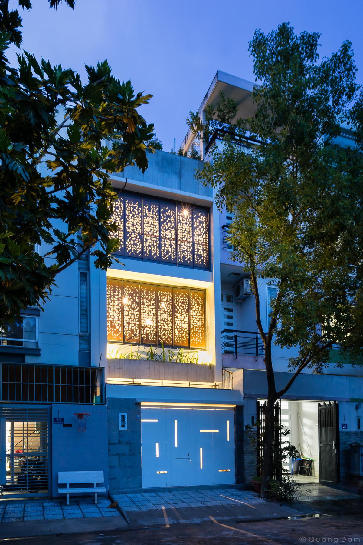 Mặt tiền nhà phố nổi bật với hệ cửa hai lớp, lớp bên ngoài là nhựa cứng cắt CNC có hoa văn đẹp mắt.