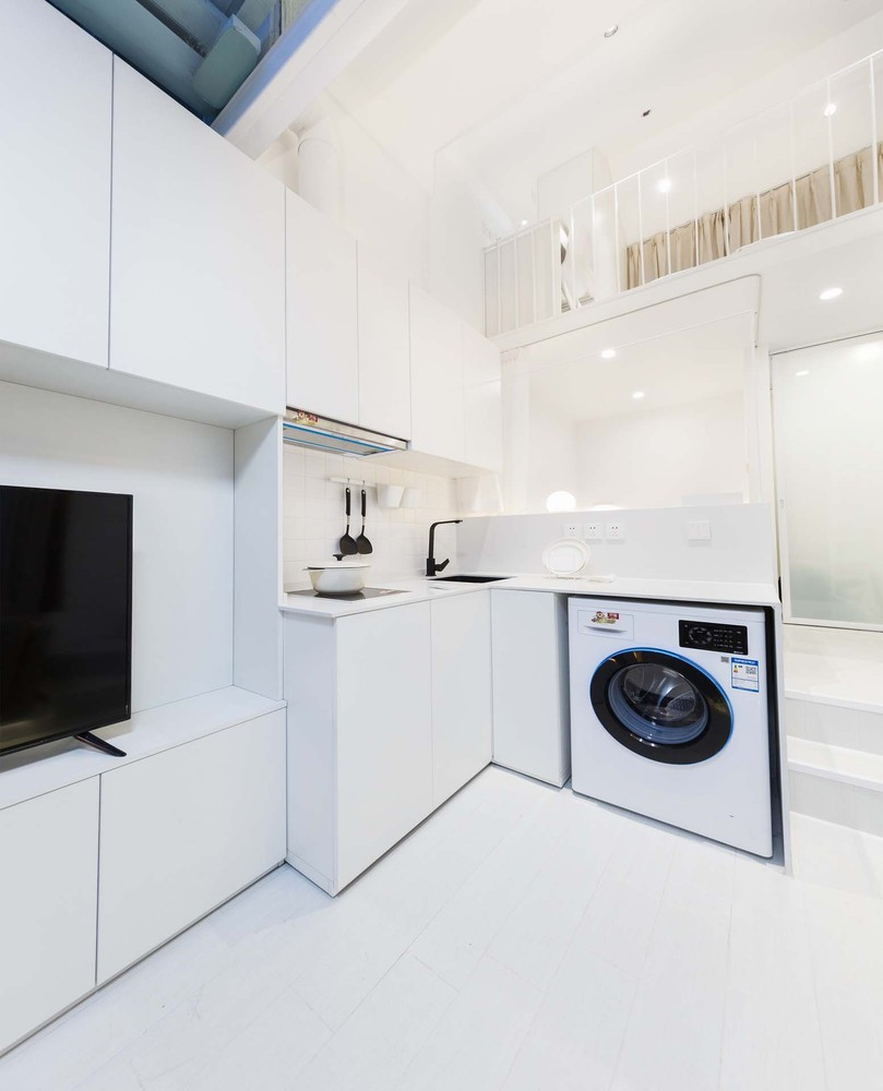 Phòng khách và bếp thiết kế chung với các kệ lưu trữ tích hợp hai không gian nhằm tận dụng tối đa không gian lưu trữ trong ngôi nhà nhỏ.