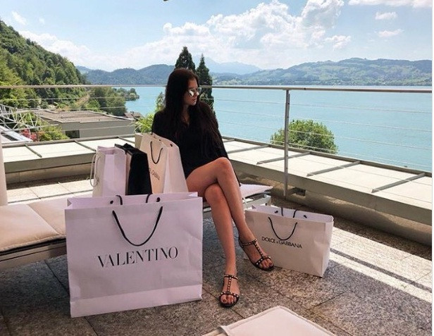 Trong khi đó, một chàng trai tạo dáng bên ngoài máy bay cá nhân với một chai Moet và túi Louis Vuitton.