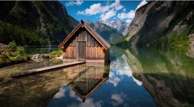 Ngôi nhà gỗ được tô điểm bởi dòng sông và dãy núi trùng điệp.