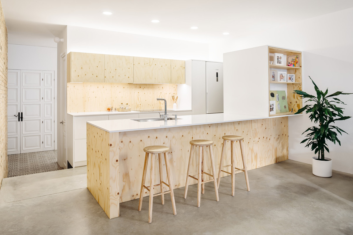 Nhà bếp tối giản với gỗ dán và mặt bàn ốp đá thạch anh.