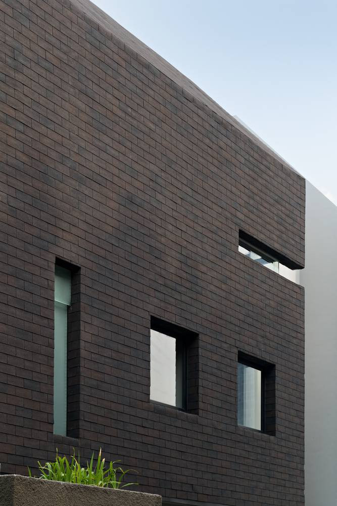 Mặt tiền ngôi nhà được xây dựng từ chất liệu nhựa đường cũng là giải pháp giảm đến 70% lượng nhiệt từ ánh sáng mặt trời đi vào nhà.