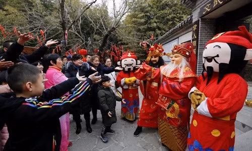 Ngày Thần Tài ở Trung Quốc, nhiều cửa hàng mở cửa, phát phiếu lì xì cho khách. Ảnh: News.