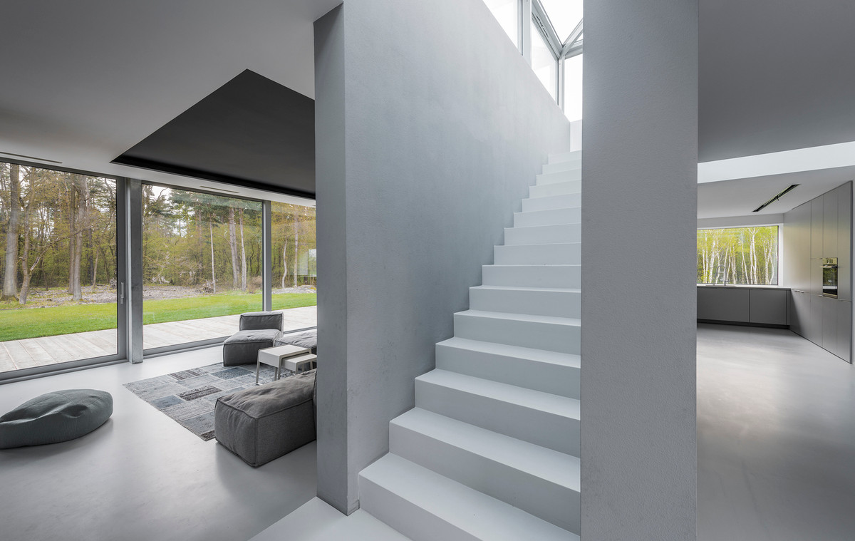 Cầu thang ngăn cách giữa phòng khách và bếp là một điểm nhấn lạ mắt của ngôi nhà. Nguồn ảnh: Archdaily.