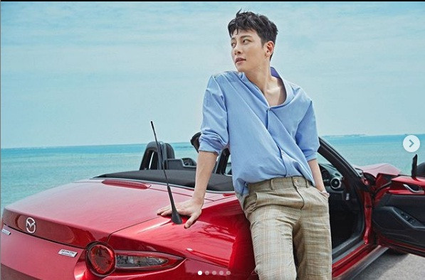 Nam tài tử "thả dáng" bên xế hộp xịn sò màu đỏ và lái xe bon bon trên đường cực kì sang chảnh. Ảnh: Instagram.