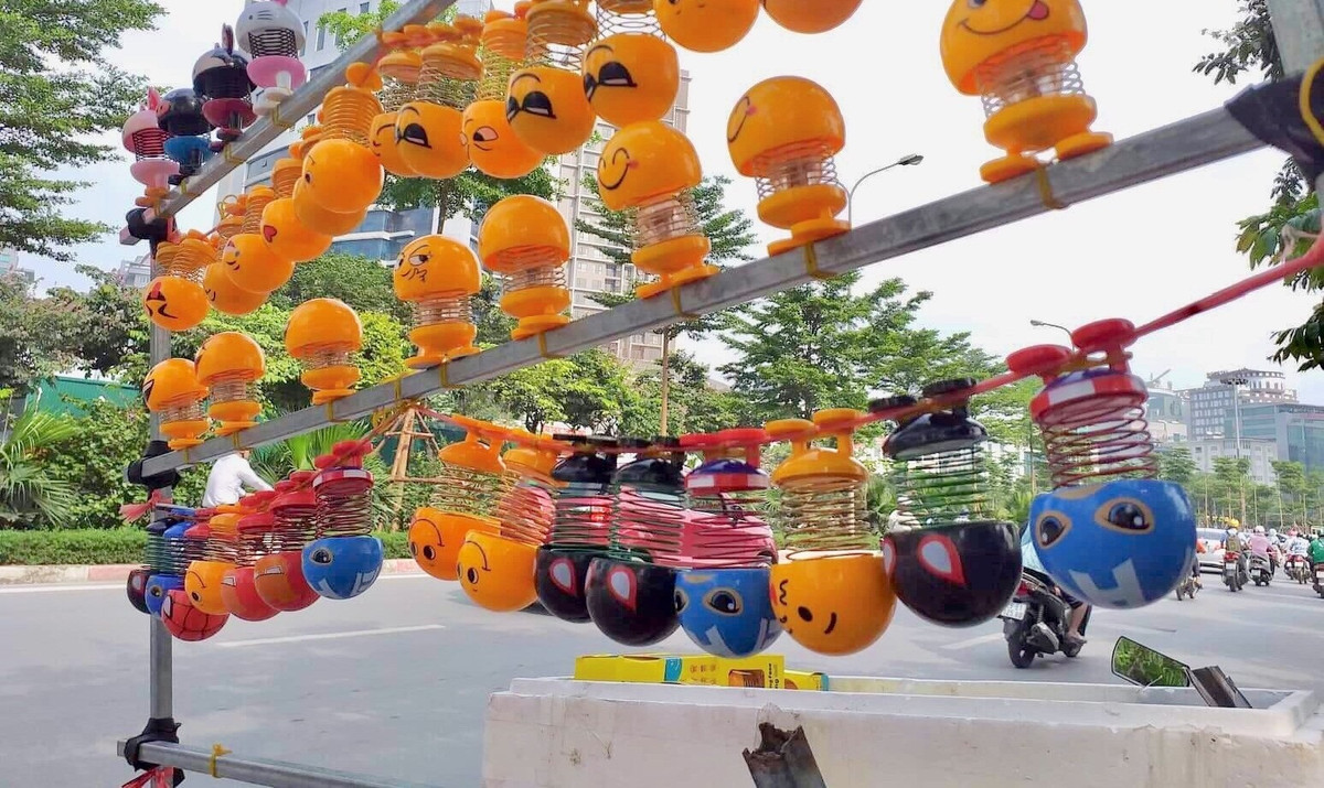 Chia sẻ trên báo Người đưa tin, chị Nguyễn Thị Hoa, người bán lò xo mặt cười trên đường Phạm Văn Bạch (Yên Hòa, Cầu Giấy) cho biết mỗi ngày bán được ít cũng hơn trăm con, trung bình từ 15.000 - 20.000 đồng/con. Ảnh: Người đưa tin.