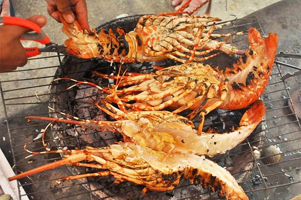 Rất nhiều khách du lịch ngang qua đây rất thích thú, ngắm nhìn rồi chụp ảnh với tôm hùm nhưng thật sự lo ngại về chất lượng. Ảnh: Bazantravel.