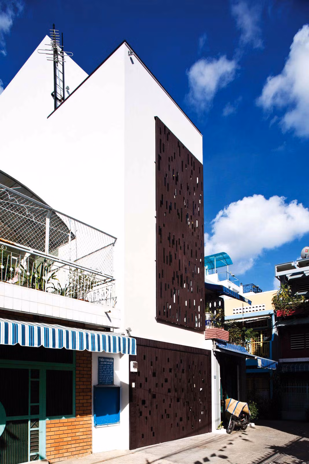 Mặt tiền ngôi nhà là một khối đơn giản với tường gạch và gỗ conwood lắp ghép thành những mảng ngẫu nhiên, tạo nên một diện mạo khác biệt. Ảnh: Noithatmagazine.