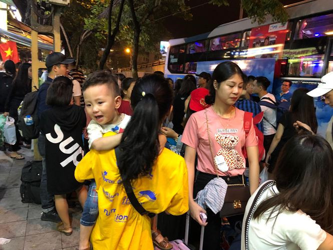 Cháu bé khóc thét lên khi thấy cảnh chen chúc, đông người lúc chờ xe.