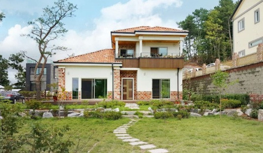 Nhà phong cách Địa Trung Hải nổi bật với sân cỏ xanh, màu sơn vàng be quen thuộc, kết hợp cùng đá tự nhiên để tạo điểm nhấn. Ảnh: Homify.